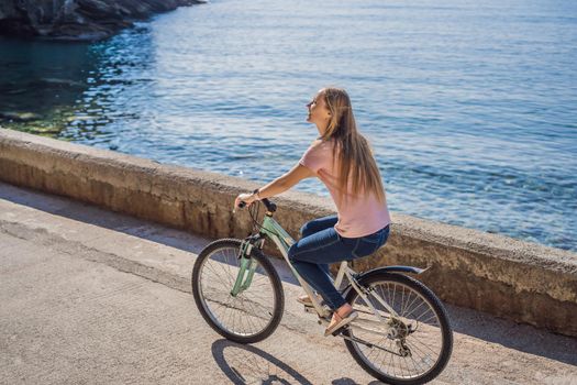 Woman tourist on a bicycle explores Budva in Montenegro. Cycling in Montenegro concept.