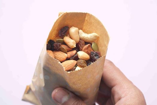 top view of many mixed nuts in a paper packet .