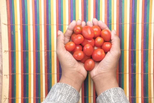 red color cherry tomato on hand top view .