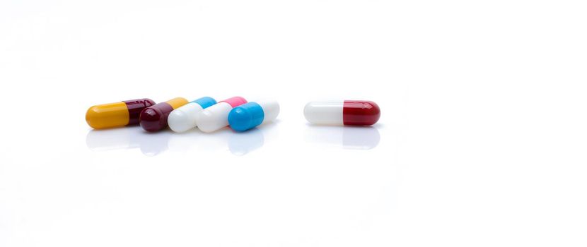 Antibiotic capsule pills on white background. Prescription drugs. Colorful capsule pills. Antibiotic drug resistance concept. Pharmaceutical industry. Superbug problem. Pharmacy horizontal web banner.