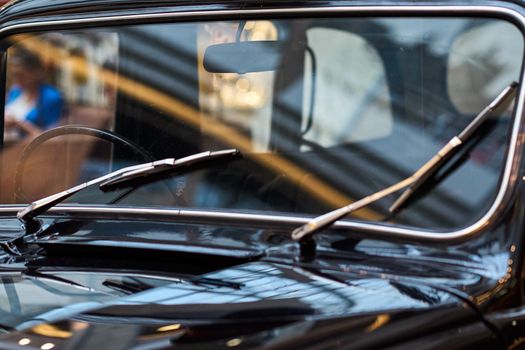 Retro car windscreen with windshields closeup. Part of black vintage car