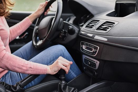 Woman driving car. Female hand change speed on manual gearbox