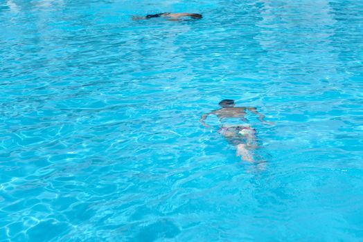 Boy in diving mask swim underwater in swimming pool