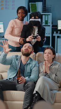 Workmates playing video games on television to have fun after work. Colleagues enjoying celebration with controller, console and vr glasses. Cheerful coworkers with technology