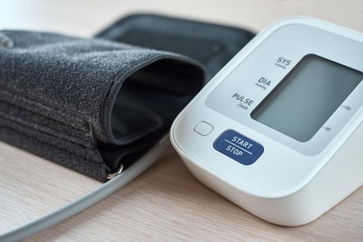 Digital blood pressure monitor on table, closeup. Helathcare and medical concept