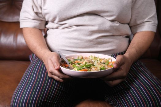 young man in casual dress eating fresh salad , healthy food concept .