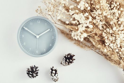 Alarm clock with decorations on white background, top view. Minimal flat lay style