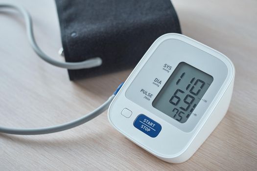 Digital blood pressure monitor on table, closeup. Helathcare and medical concept