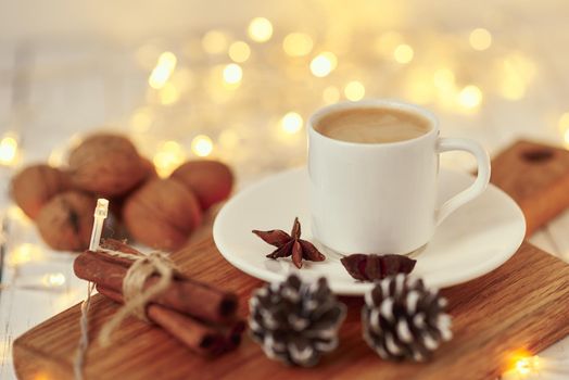 Cozy autumn or winter concept. Cup of coffee with garland lights and decoration/