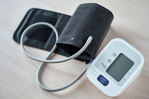 Digital blood pressure monitor on table, closeup. Helathcare and medical concept