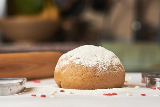 ball of raw dough sprinkled with flour on table