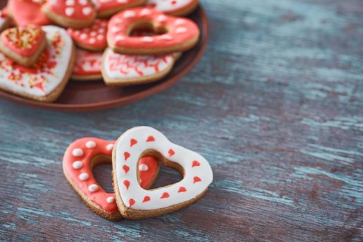 Two heart shape cookies and many decorated cookies on gray background. Valentines Day concept