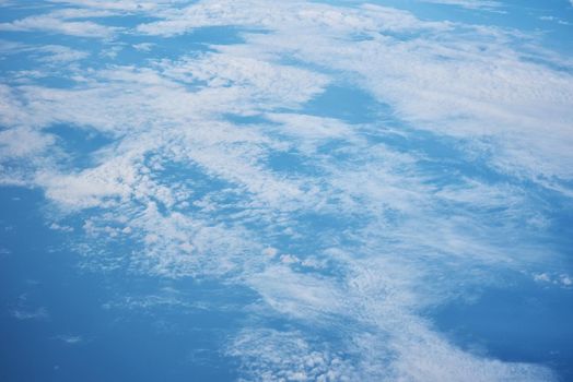 Blue cloudy sky, view from airplane window. Aerial view of cloudscape