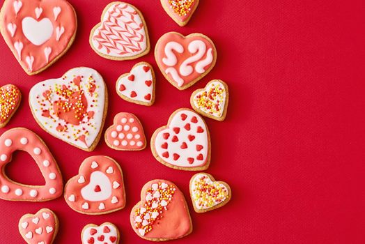 Glazed with icing heart shape cookies on red backgroundwith copy space. Valentines Day food concept