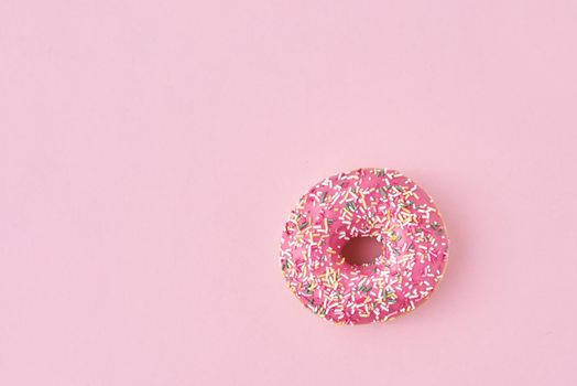 donats decorated sprinkles and icing on pink background. Creative and minimalis food concept, top view flat lay