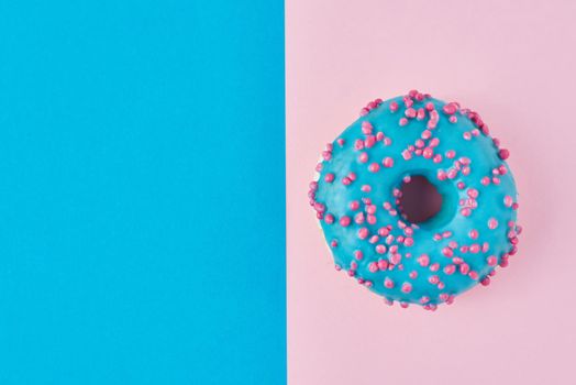 donut on pastel pink and blue background. Minimalism creative food composition. Flat lay style