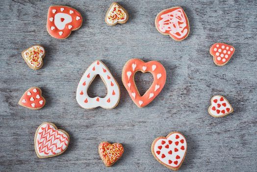 Frame with glazed and decorating heart shape cookies on gray background. Valentines Day food concept