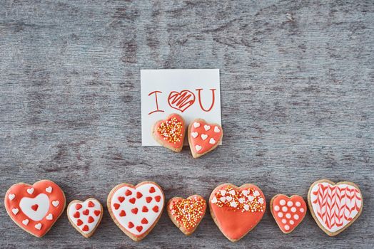 Decorated heart shape cookies and paper sheet with inscription i love you on gray background. Valentines Day concept