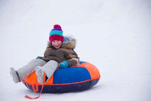 Sledding.Happy child on vacation. Winter fun and games.Little boy enjoying a sleigh ride.Children play outdoors in snow. Kids sled in the Alps mountains in winter