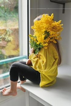 A girl holding mimosa on a white background