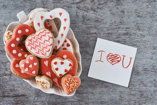 Decorated heart shape cookies and paper sheet with inscription i love you on gray background. Valentines Day concept