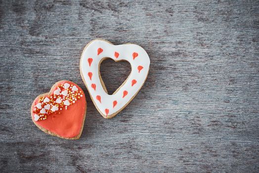 Two decorated heart shape cookies on gray background with copy space. Valentines Day food concept