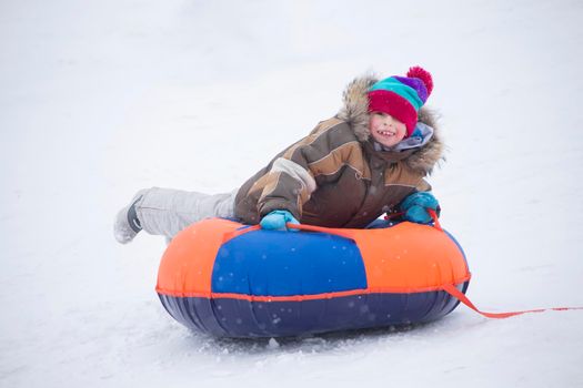 Sledding.Happy child on vacation. Winter fun and games.Little boy enjoying a sleigh ride.Children play outdoors in snow. Kids sled in the Alps mountains in winter
