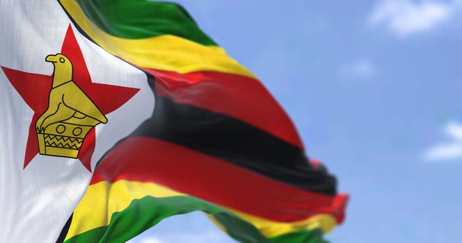 Detail of the national flag of Zimbabwe waving in the wind on a clear day. Zimbabwe is a landlocked country located in Southeast Africa. Selective focus.