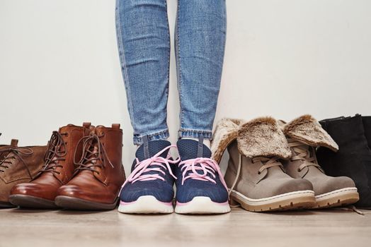 Woman chooses comfortable brown leather shoes among bunch of different pairs