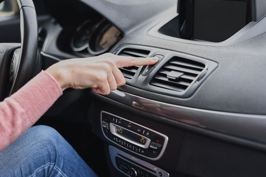 Woman hand press emergency stop button in the car