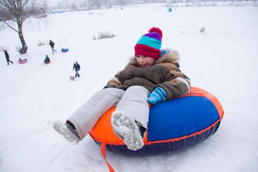 Sledding.Happy child on vacation. Winter fun and games.Little boy enjoying a sleigh ride.Children play outdoors in snow. Kids sled in the Alps mountains in winter