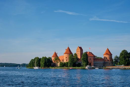 Trakai Island Castle in lake Galve with boats and yachts in summer day with beautiful sky, Lithuania. Trakai Castle is one of major tourist attractions of Lituania