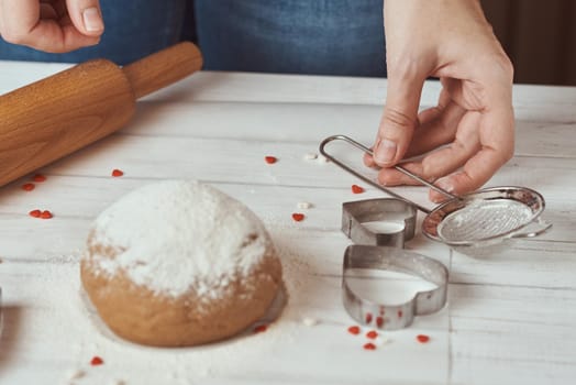 Woman kneads dough with hands in kitchen