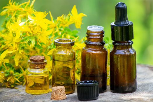 St. John's wort flower oil in a glass bottle. on a wooden background. Selective focus