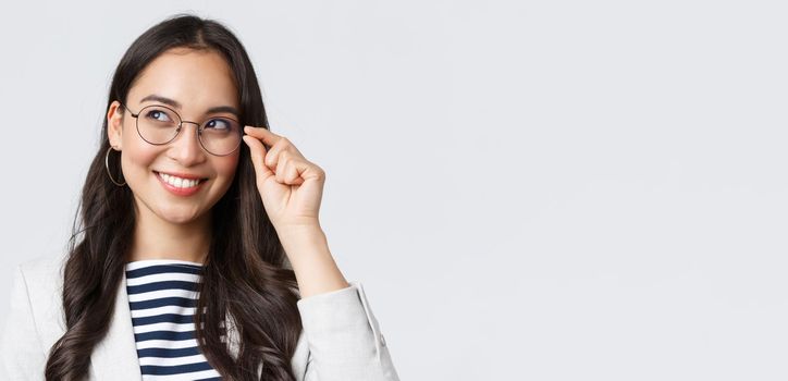 Business, finance and employment, female successful entrepreneurs concept. Close-up of dreamy and thoughtful smart asian woman, office worker in glasses, smiling and looking left.