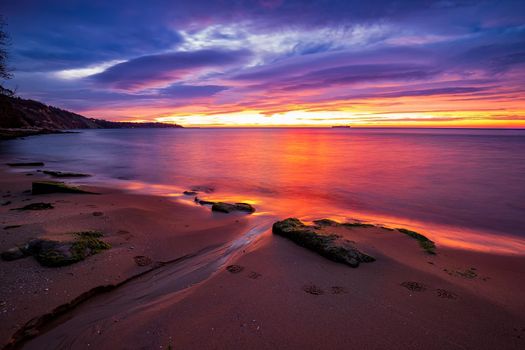 Exciting long exposure red sunrise over the sea.