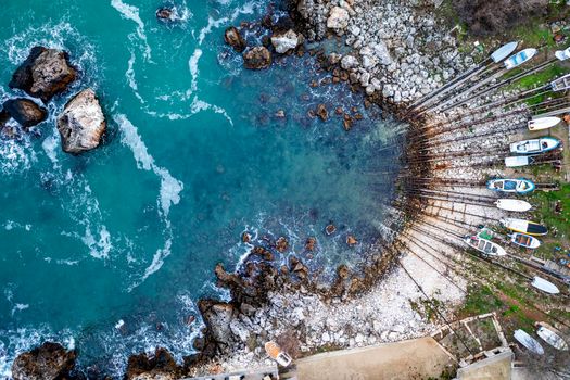 Aerial top view at the small bay and pier with fishing boats on the shore