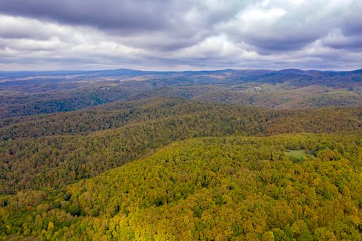 Drone Aerial View view of mountain hills. Hilltops covered with autumn forest.