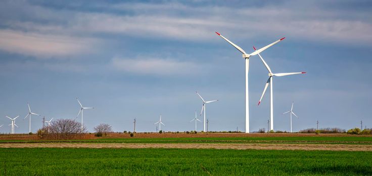 Panoramic view of a wind turbine farm the blue day sky