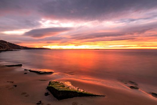 Exciting long exposure red sunrise over the sea.