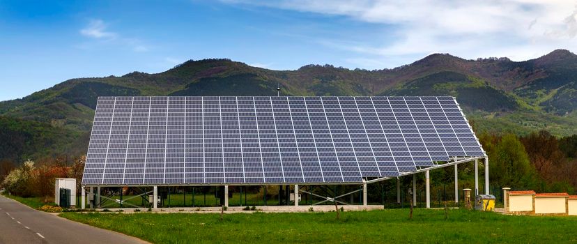 solar panels on the roof of a house. horizontal orientation, a mountain in the background