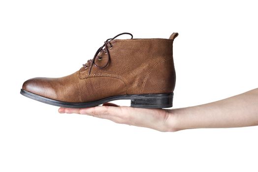 Female hand holding brown leather womens boot on white background isolated