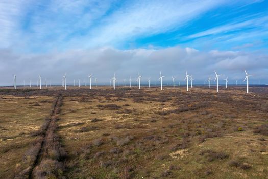 Aerial view to wind turbine farm. Horizontal view with cloudy sky