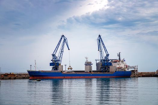 trading ship of the port city ready for loading materials with the cranes.