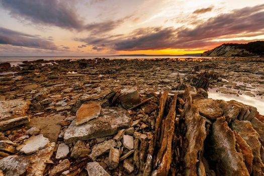 Exciting sunset at sea rocky coast and colorful sky