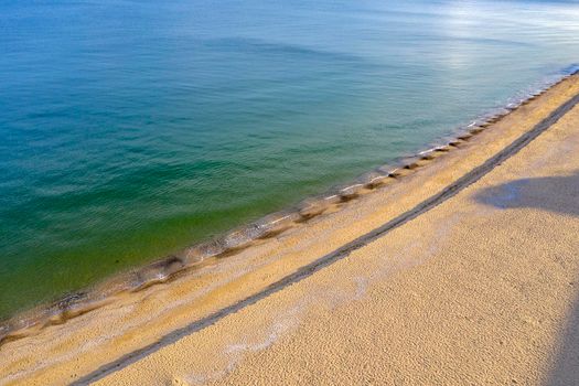 Aerial top view from drone to the coastline. Calm sea and sand