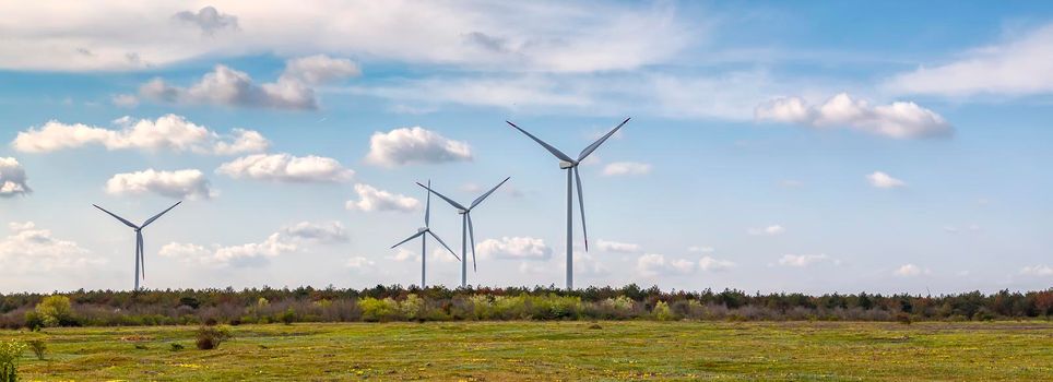 Panoramic view of a wind turbine farm the blue day sky