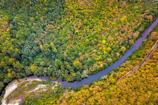 Aerial view from drone of the river across mountain hills with autumn trees