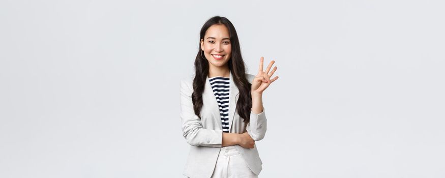 Business, finance and employment, female successful entrepreneurs concept. Successful female businesswoman, asian real estate broker pointing finger, showing number four and smiling.