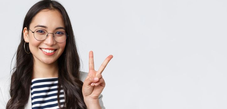 Business, finance and employment, female successful entrepreneurs concept. Close-up of friendly outgoing asian office employee showing peace sign and smiling optimistic, have all under control.